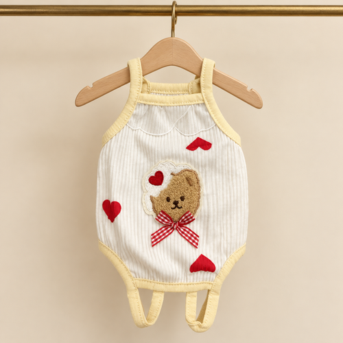 Ivory ribbed cotton pet bodysuit with butter yellow binding, a bear patch with red gingham bow and red heart appliques